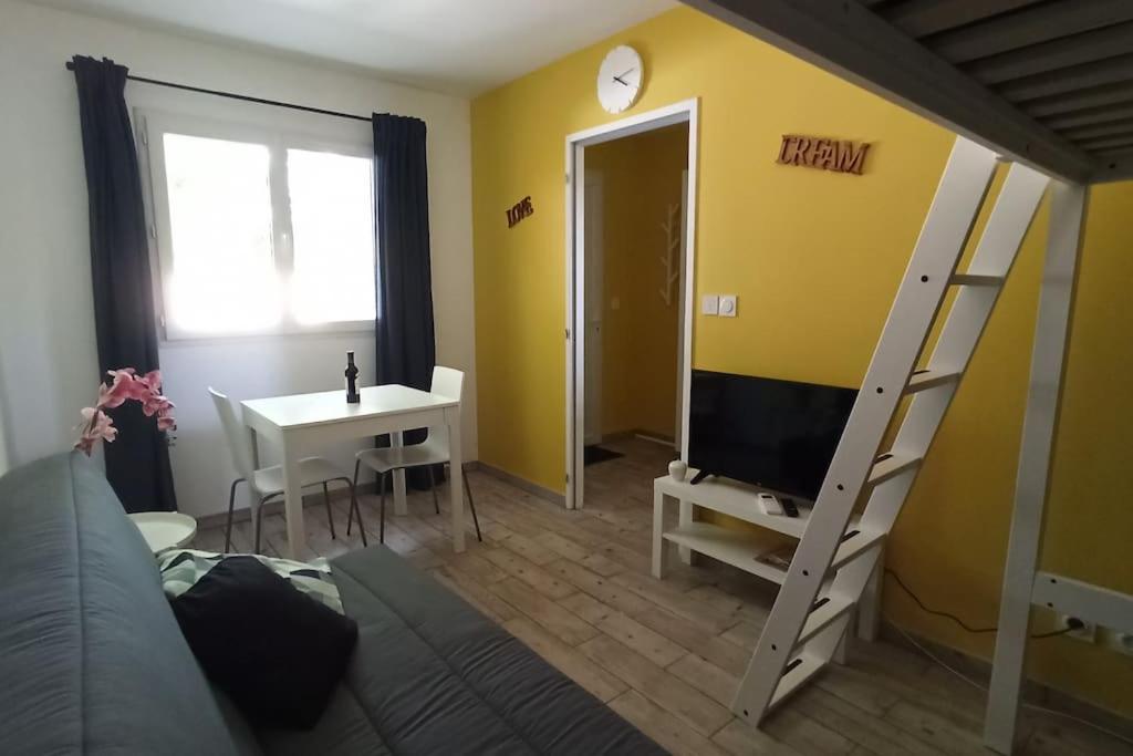 a living room with a bed and a tv and a desk at T1 cosy climatisé indépendant sur prop privée à Sanguinet - lac, océan, Bassin d'Arcachon, Dune du Pyla in Sanguinet