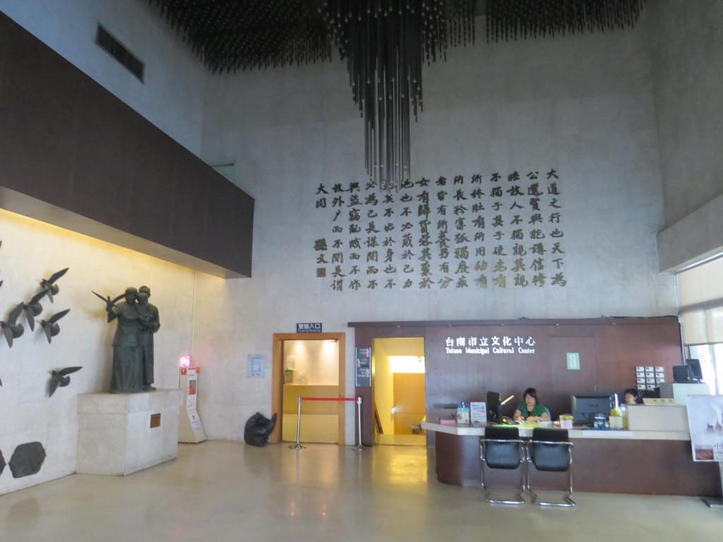 a lobby with a woman sitting at a counter in a building at @ Tainan Inn in Tainan