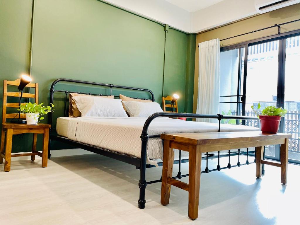 sypialnia z łóżkiem i zieloną ścianą w obiekcie Grasshopper Bed and Cafe w mieście Pak Kret