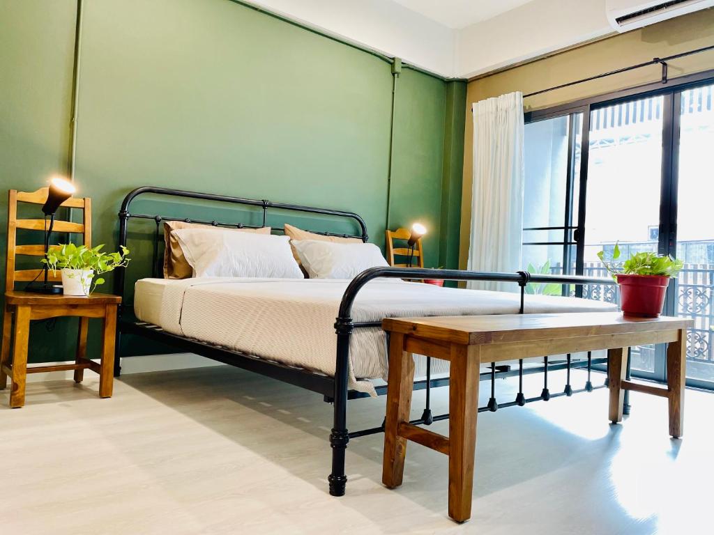 北革Grasshopper Bed and Cafe的带床和绿墙的卧室