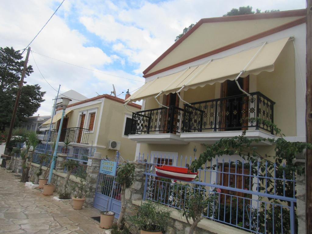 a house with balconies and a fence at Chryssa Rooms in Symi