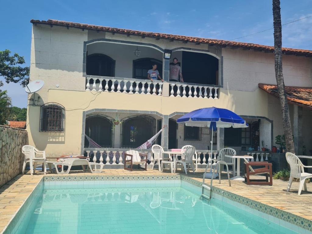 a man is looking out of the window of a house at Hostel Iguabella - RJ in Iguaba Grande