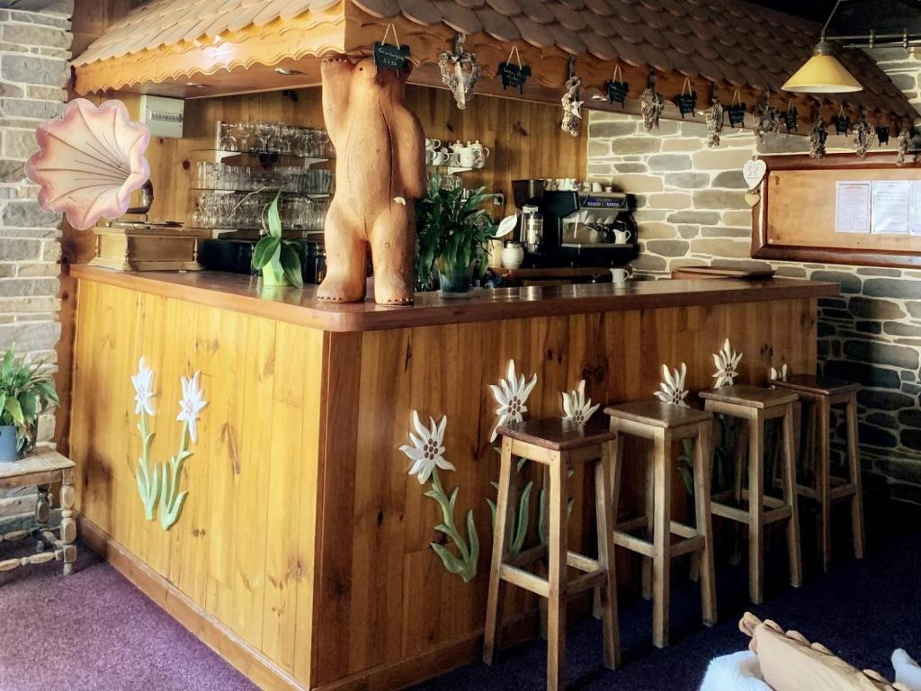 un bar avec une statue d'ours au-dessus. dans l'établissement Hotels Les Catrems & Le Montagnou, à Orcières