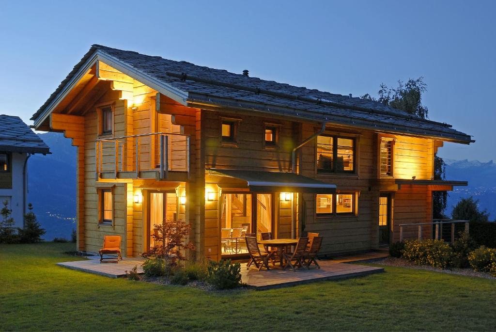 Cette grande maison en bois comprend une table et des chaises. dans l'établissement Chalet CALIN NEND100, à Nendaz