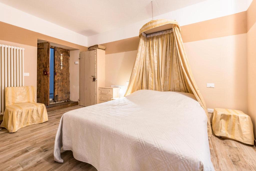 ein Schlafzimmer mit einem Himmelbett in der Unterkunft Agriturismo Al Gallo Nero Miele in Tenno