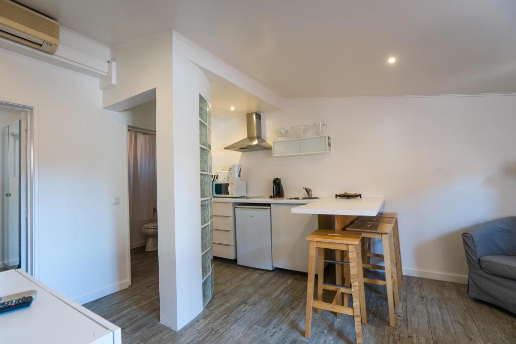a kitchen and living room with a table and chairs at Quinta da Bicuda in Cascais