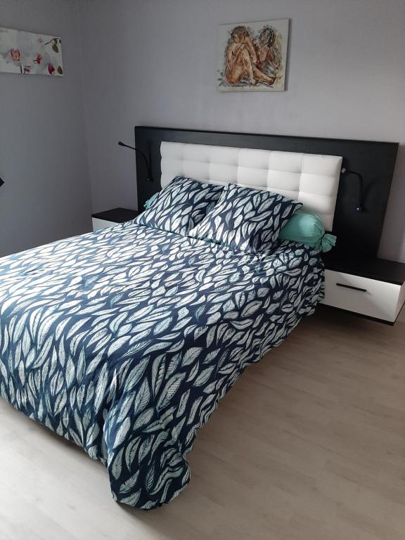 een slaapkamer met een bed met een zwart-wit dekbed bij Les deux anes in Veuves