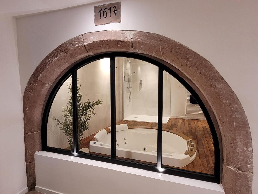 a bath tub in a room with a window at Jacuzzi des Tanneurs in Ribeauvillé