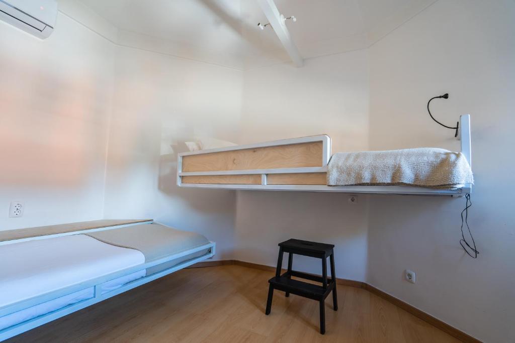 a small room with a bunk bed and a stool at Quinta da Bicuda in Cascais