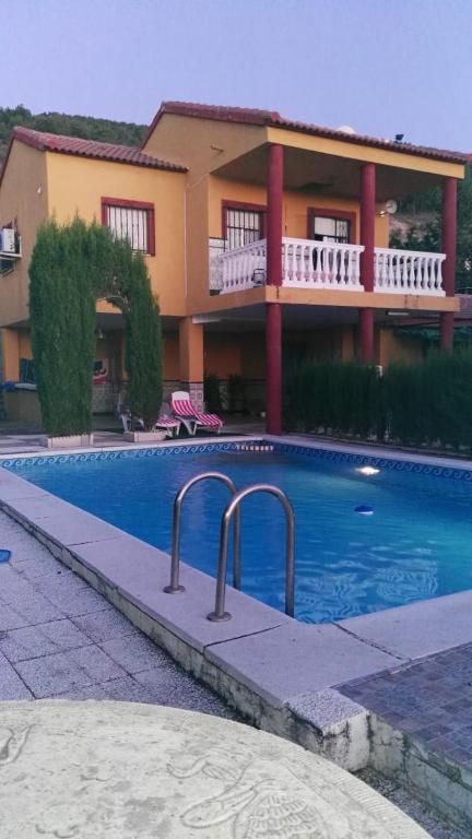 a house with a swimming pool in front of a building at Vivienda Rural Villa Ruben in Jaén