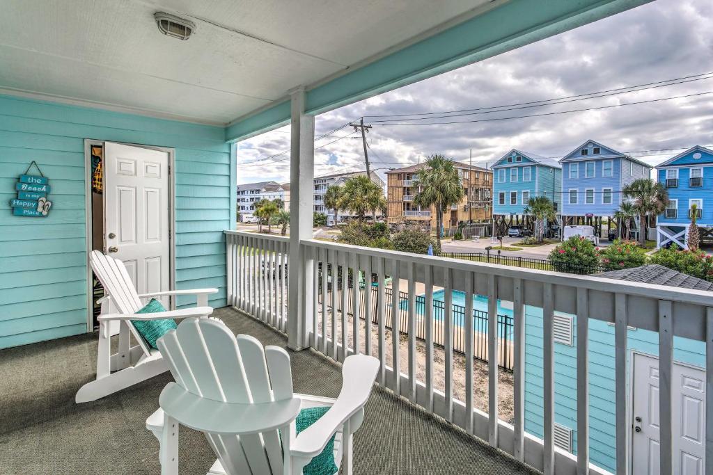 a balcony with white chairs and a blue house at Surfside Beach Escape with Pool - Walk to Ocean! in Myrtle Beach