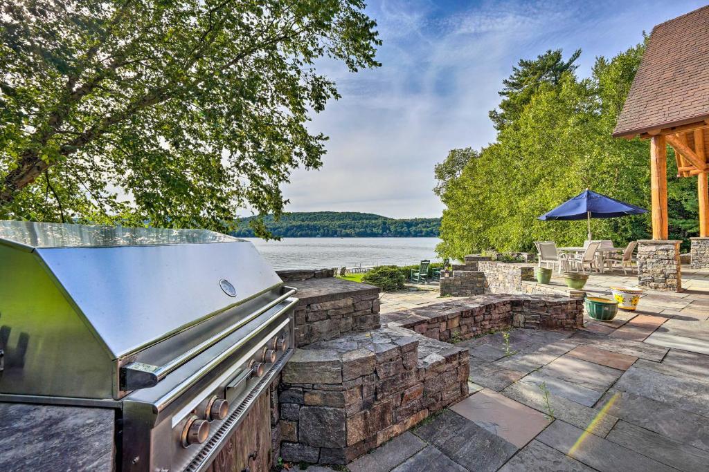 una cocina al aire libre con parrilla y un lago en Stunning Vermont Cabin with Private Lake Access, en Poultney