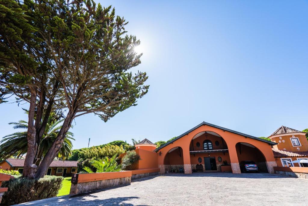 an orange building with a tree in front of it at Quinta da Bicuda in Cascais