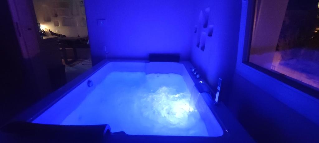 a dark room with a bath tub with blue lights at Casa Mediterranea Jacuzzi riscaldata con Caminetto in Specchiolla