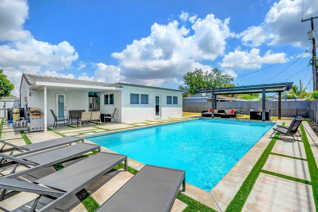 a swimming pool with chairs and a house at Cozy paradise, with heated pool, near Airport in Miami L16 in Miami