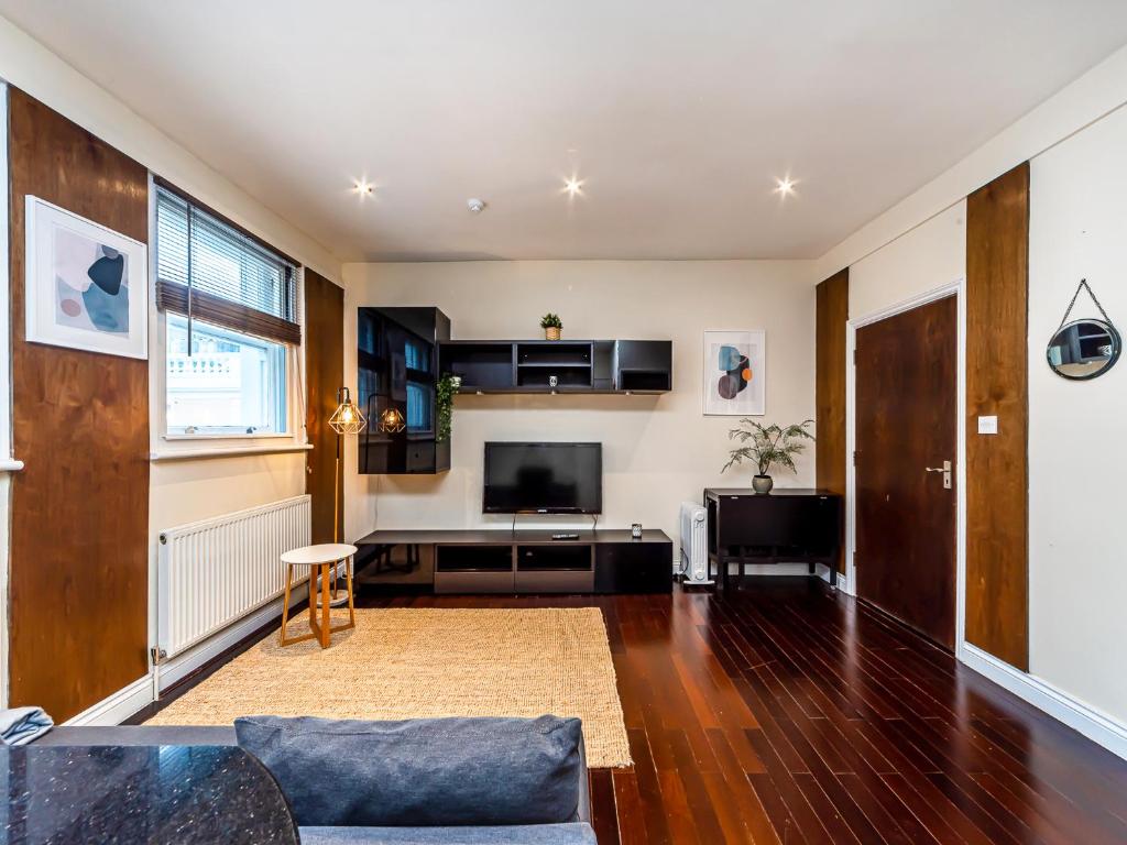 a living room with a couch and a tv at Pass the Keys - Holborn Apartment Close to Everything in London