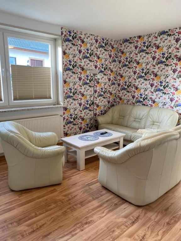 uma sala de estar com dois sofás e uma mesa em familienfreundliche Ferienwohnung Tina em Rollshausen