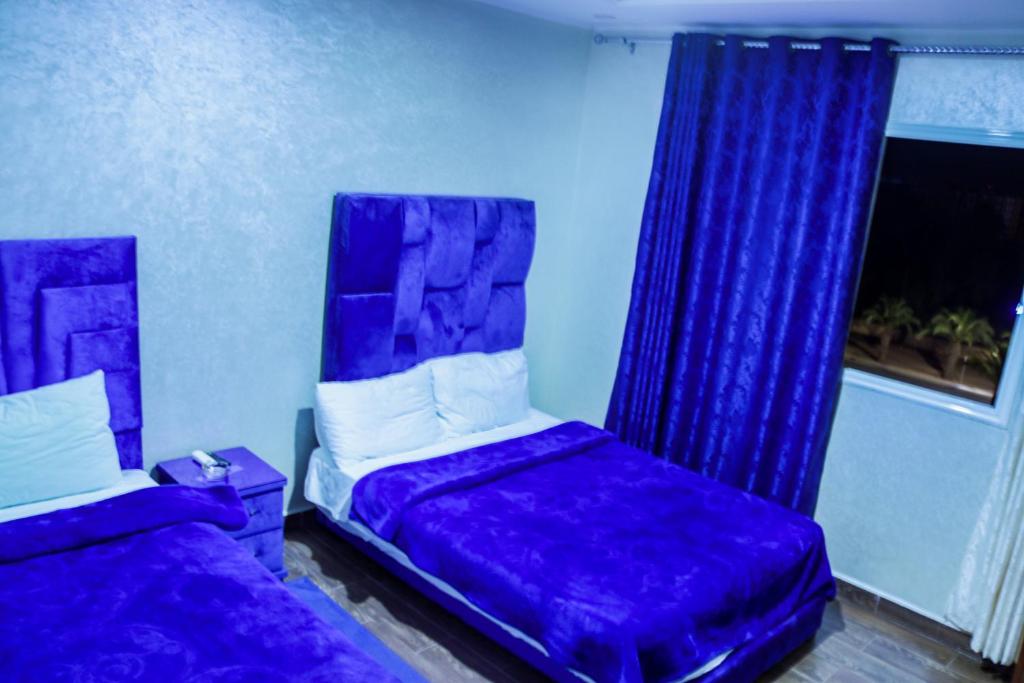 a bedroom with a purple bed and a window at HOTEL BORJ EL ARAB in Khouribga