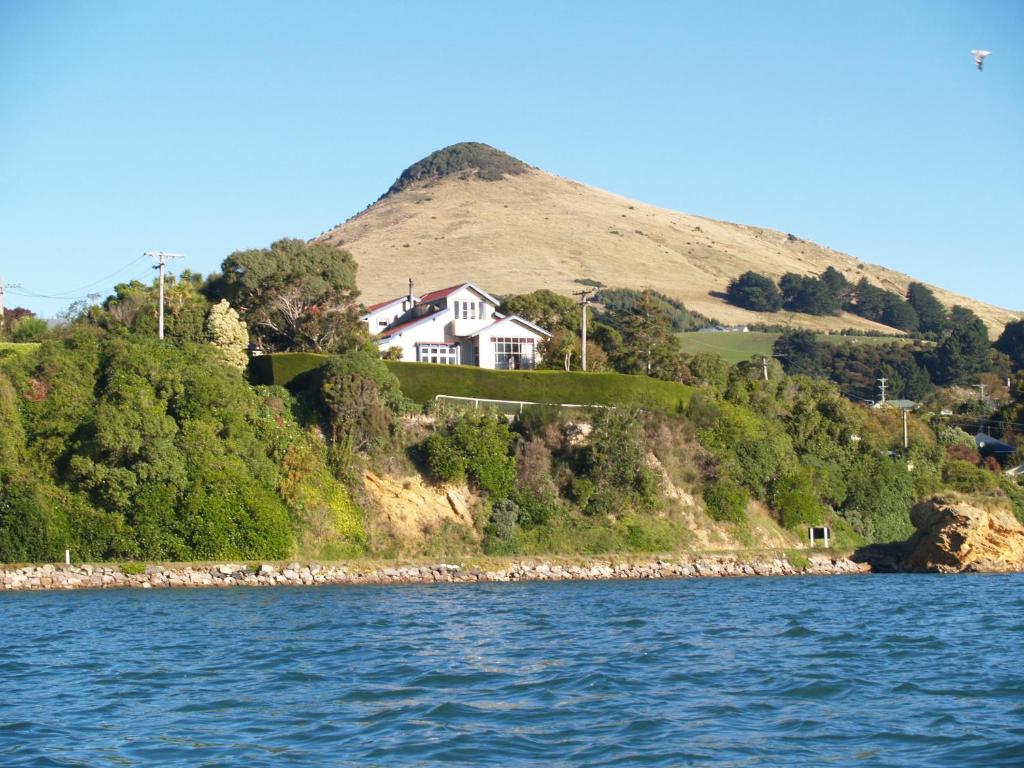 a house on top of a hill next to the water at Captain Eady's Lookout in Portobello