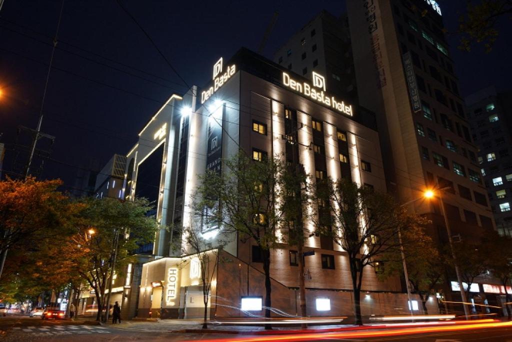 a building with a sign on it at night at Denbasta Hotel in Busan