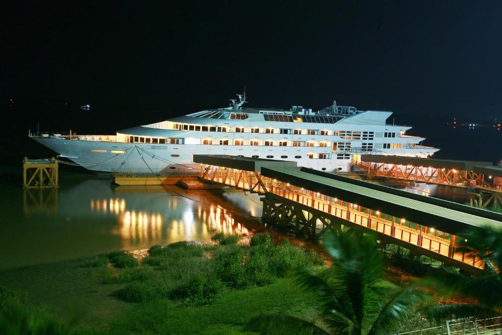 um grande navio de cruzeiro na água à noite em Vintage Luxury Yacht Hotel em Yangon