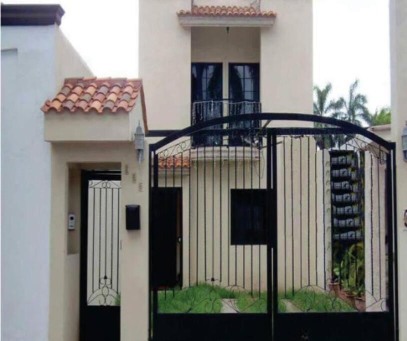 una puerta frente a una casa blanca en “SCALLY CASA ENTERA”Los Mochis, la mejor ubicación, en Los Mochis