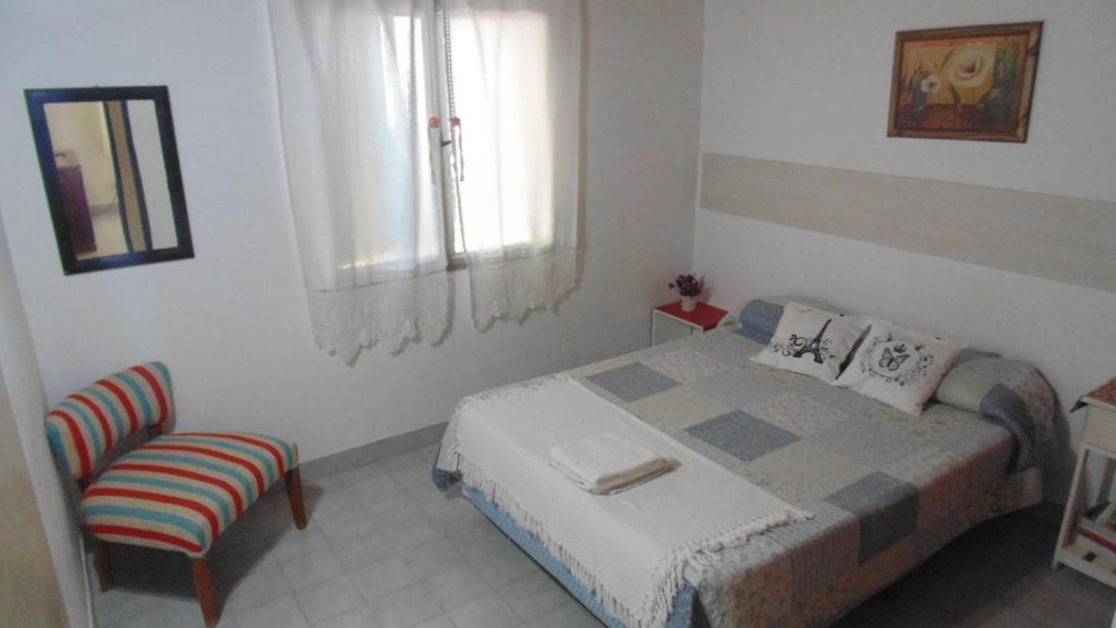 a small bedroom with a bed and a chair at Casa Las Calas in Puerto Madryn