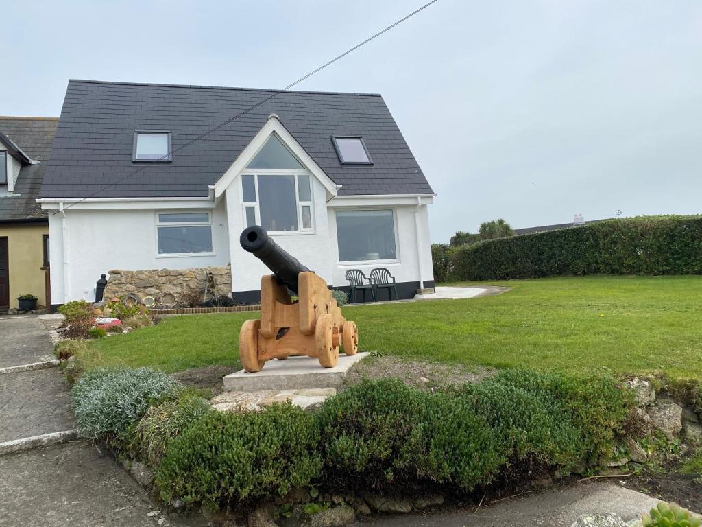 una estatua de un cañón delante de una casa en Appletree en Hugh Town