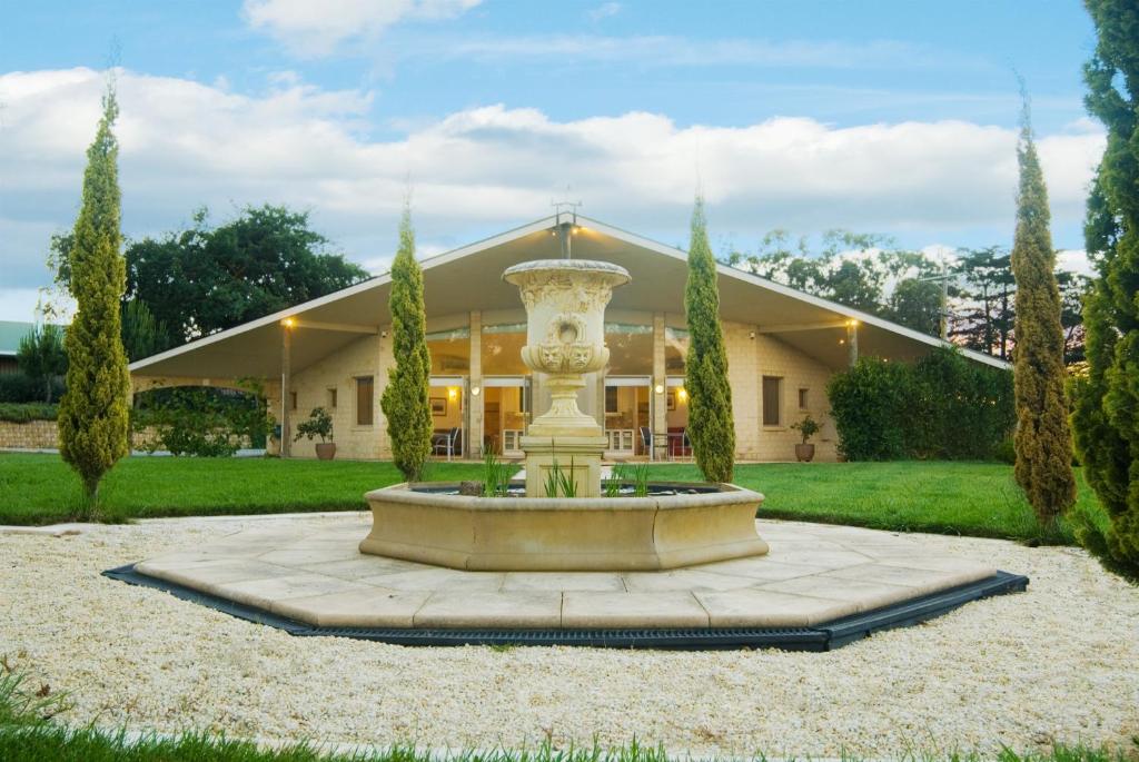 a large building with a fountain in the middle of a yard at The Gatehouse at Villa Raedward in Yering