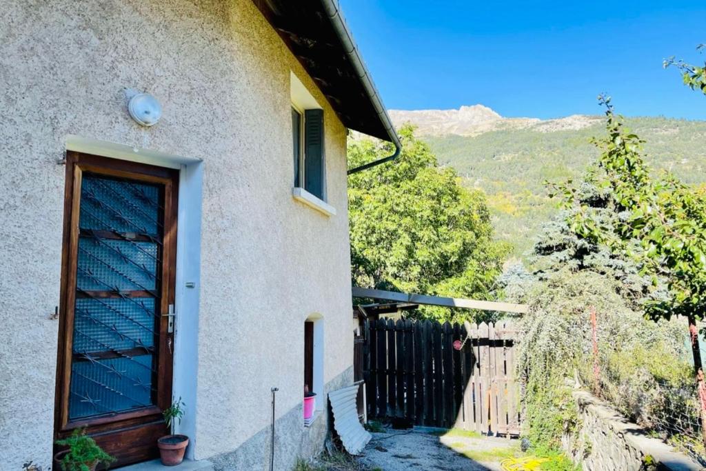 ein Haus mit einer Tür und einem Zaun in der Unterkunft Nice Chalet With View On The Mountain in La Salle Les Alpes