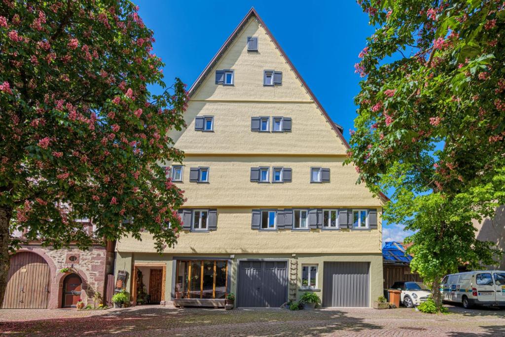 a large yellow house with a pointed roof at Apartments im Ferienhaus zum alten Spital in Dornstetten