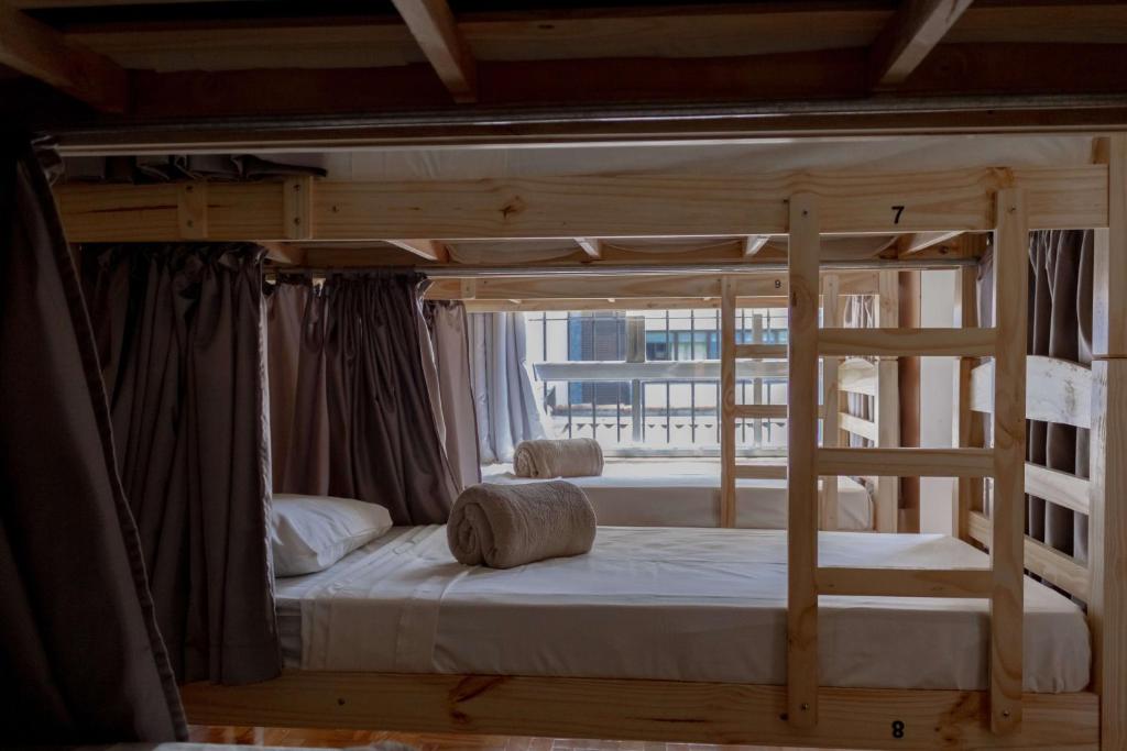 a wooden bunk bed in a room with a window at HOSTEL CUARTO in Sao Paulo