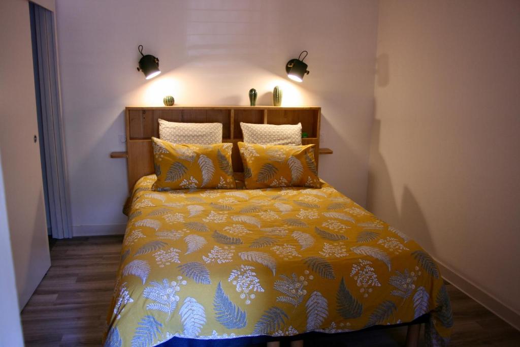 a bedroom with a bed with a yellow comforter at Appartement T2 centre historique de Morlaix in Morlaix