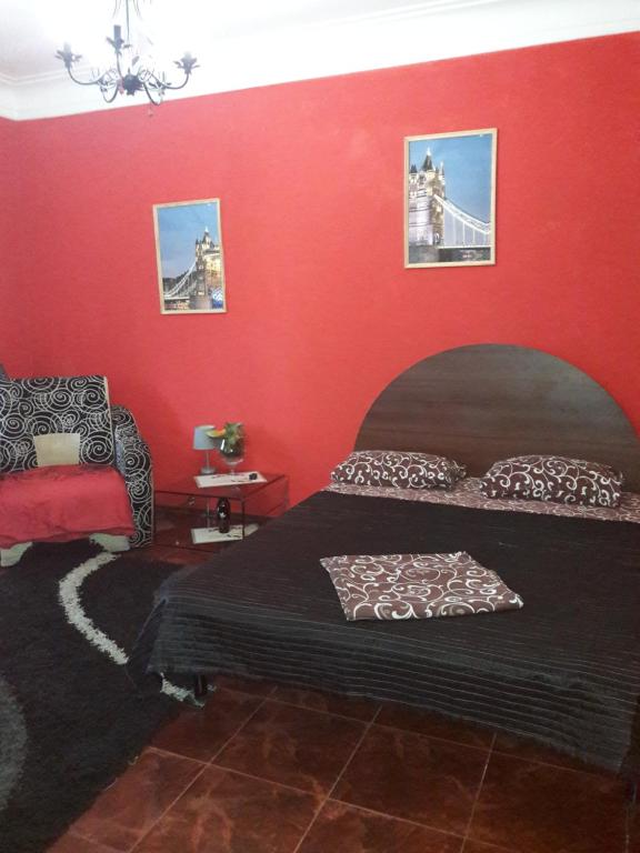 ザポリージャにあるApartment on Boulevard Shevchenkoの赤い壁のベッドルーム1室(ベッド1台付)