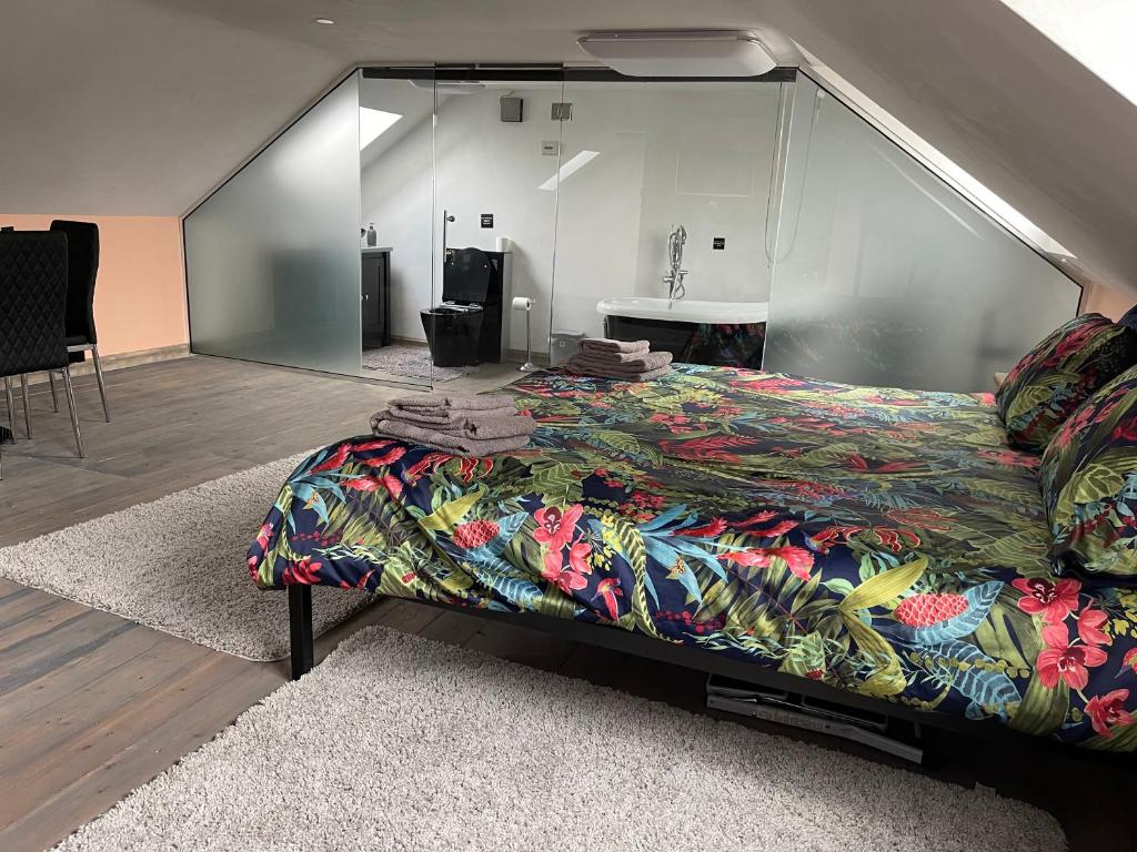 a bedroom with a large bed with a colorful blanket at Robinas Cotswold Coach House in Witney