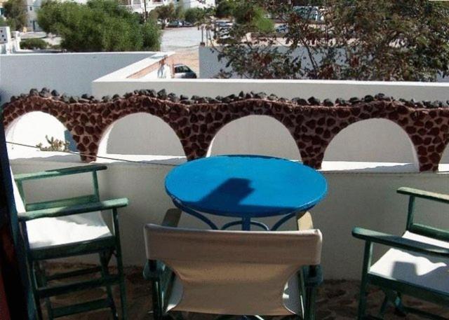 a blue table and chairs on a balcony at Studios Irineos in Perissa