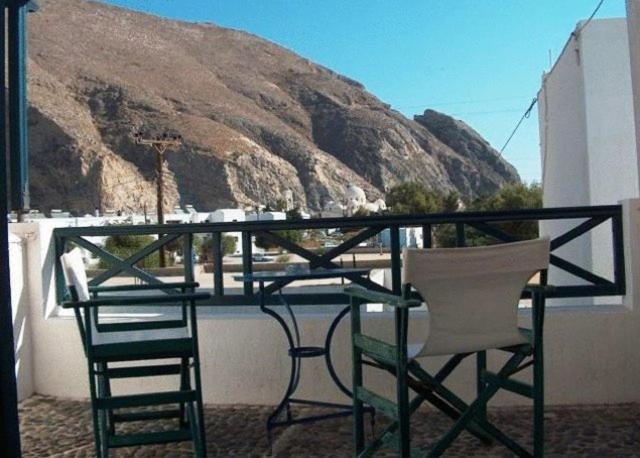 two chairs and a table on a balcony with a mountain at Studios Irineos in Perissa