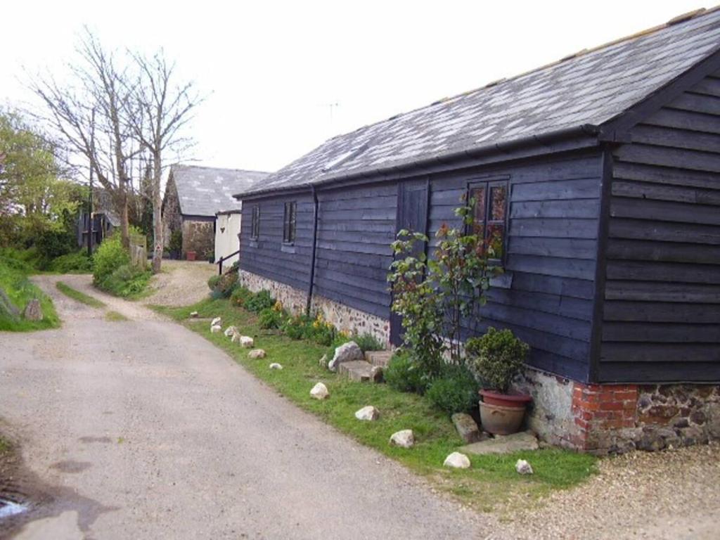 a blue house with a road next to it at Sycamores Barn - Detached, Private, Secluded Country Retreat in Brighstone