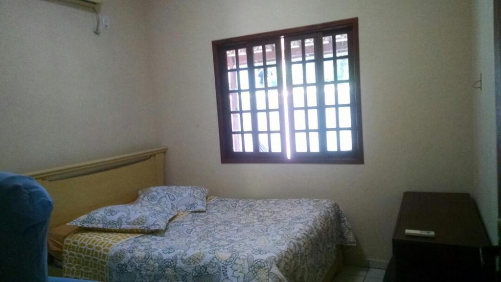 ein Schlafzimmer mit einem Bett und einem Fenster in der Unterkunft Casa Temporada Prainha de Mambucaba Paraty RJ in Paraty