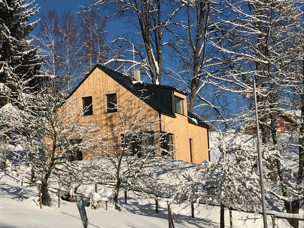 una casa de madera en la nieve con árboles en Chata Lahvanka, en Vítkovice