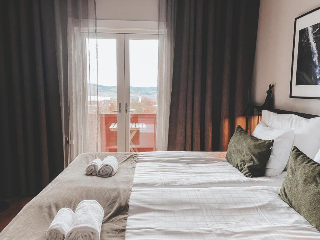 een slaapkamer met een groot bed en handdoeken bij Siljansnäs Hotell in Siljansnäs