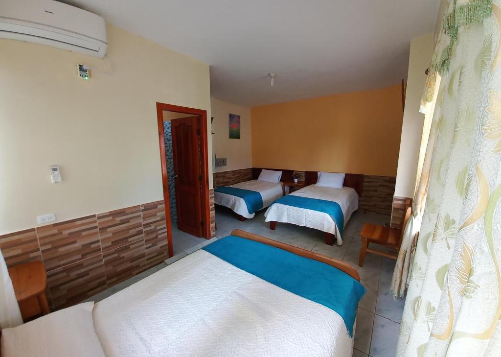 ein Hotelzimmer mit 2 Betten und einem Fenster in der Unterkunft HOSTAL JANET STARLiNK in Puerto Villamil