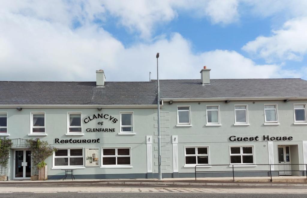 um edifício branco com uma casa de hóspedes numa rua em Clancys Of Glenfarne em Glenfarne