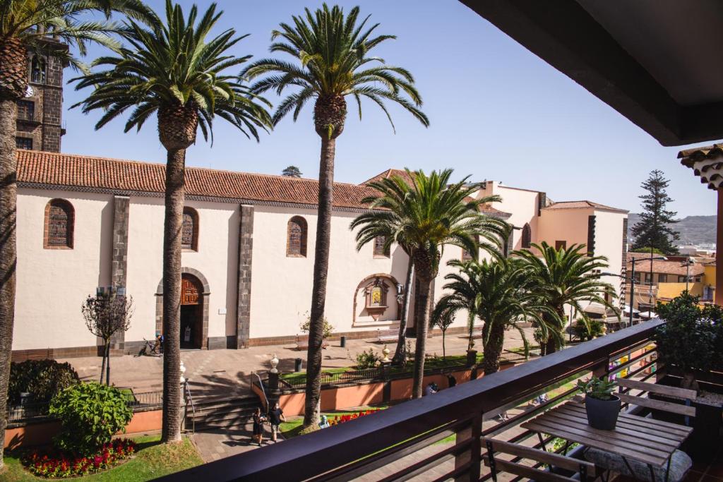 a balcony with palm trees and a building at La Laguna Treasure: exclusiveness prime location in La Laguna