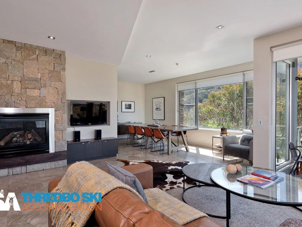 a living room with a couch and a fireplace at The Peak 5 in Thredbo