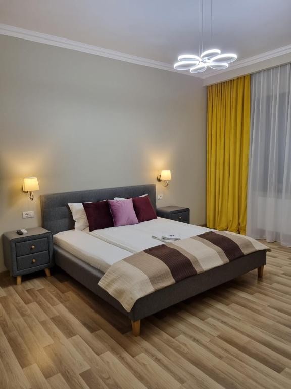 a bedroom with a large bed and a ceiling fan at City Inn Premium Apartment 2 in Timişoara