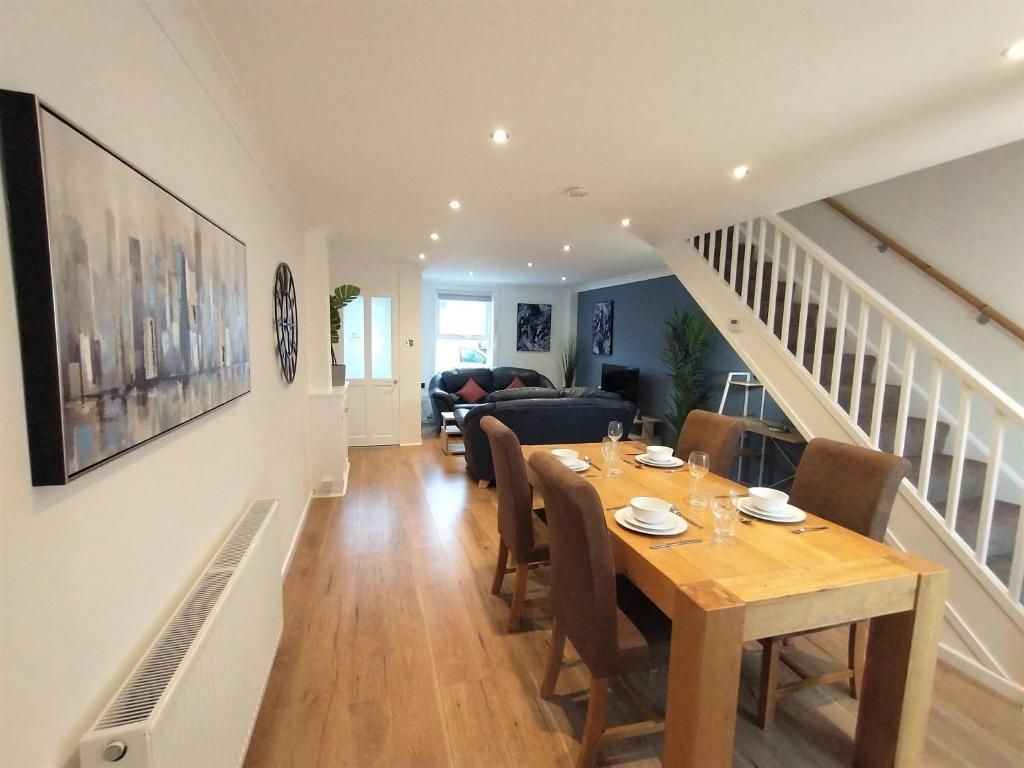 a dining room and living room with a table and chairs at ChiPad Duo - Comfy house with garden & parking in Chichester