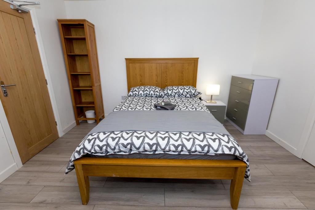 um quarto com uma cama com um edredão preto e branco em Comfortable stay in Shirley, Solihull - Room-2 em Solihull