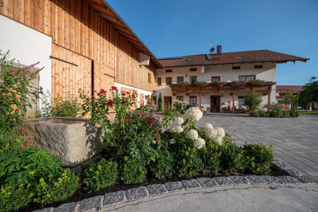 un jardín frente a un edificio con flores en Utznhof, en Seeon-Seebruck