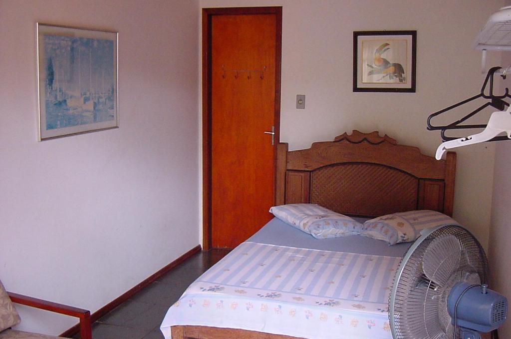 a bedroom with a bed with a fan and a door at MIAU Maison Internacional Alojamento Urbano in Foz do Iguaçu